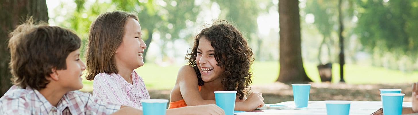 Crianças em um parque aproveitando o Dia das Crianças com um lanche saudável