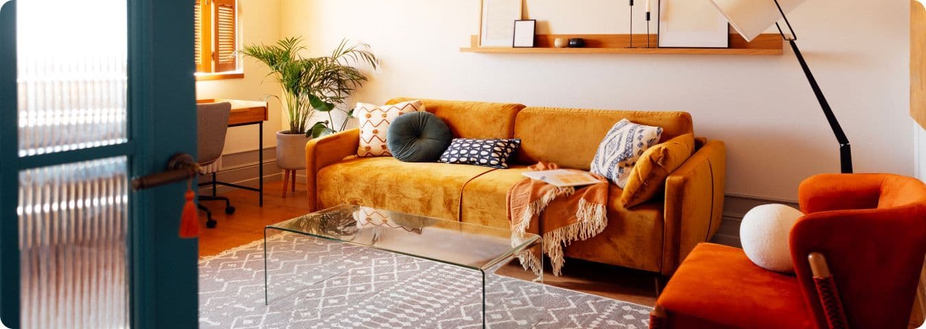 Sala de estar aconchegante com uma elegante poltrona e um sofá laranja moderno